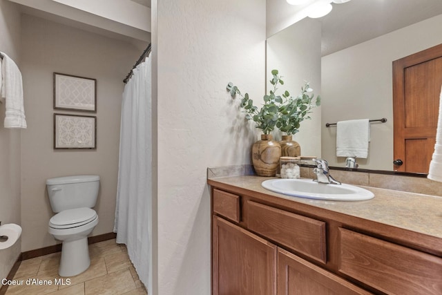 bathroom with toilet, vanity, and tile patterned flooring