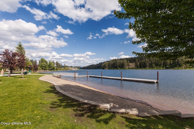 view of dock featuring a water view and a yard