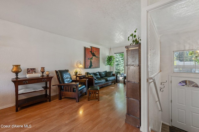 foyer entrance with light hardwood / wood-style floors and a textured ceiling