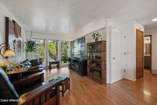 living room featuring a textured ceiling and light wood-type flooring