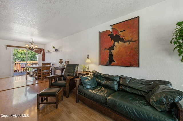 living room with a textured ceiling, a chandelier, and hardwood / wood-style flooring