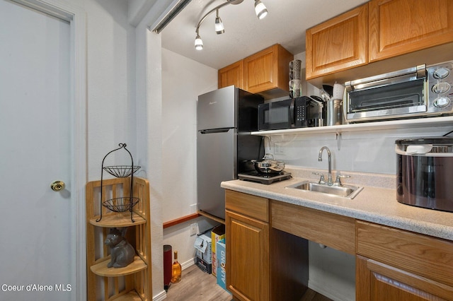 kitchen featuring sink, track lighting, and light hardwood / wood-style floors