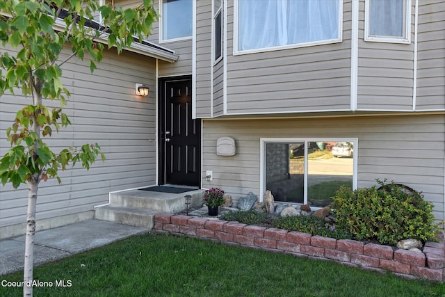 property entrance featuring a lawn