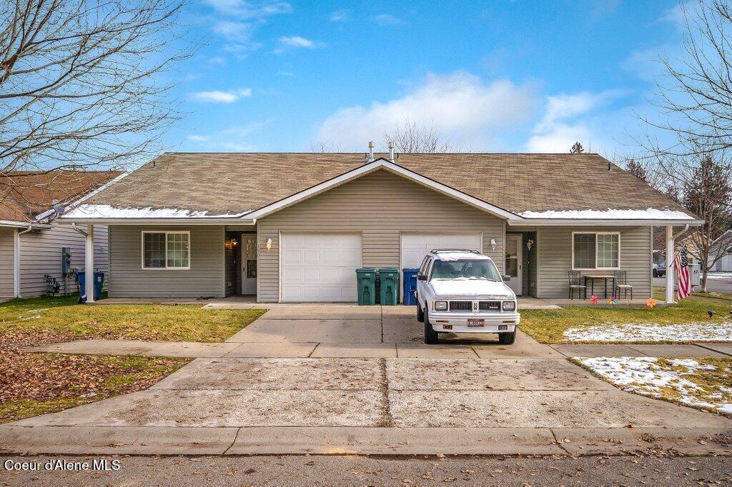 ranch-style home featuring a porch, a front yard, and a garage