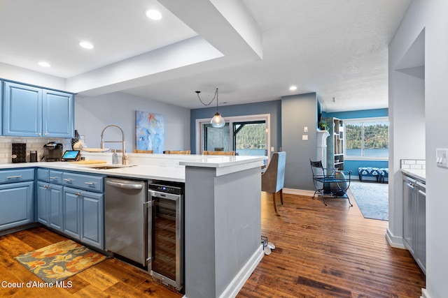 kitchen featuring kitchen peninsula, stainless steel dishwasher, wine cooler, dark hardwood / wood-style flooring, and sink