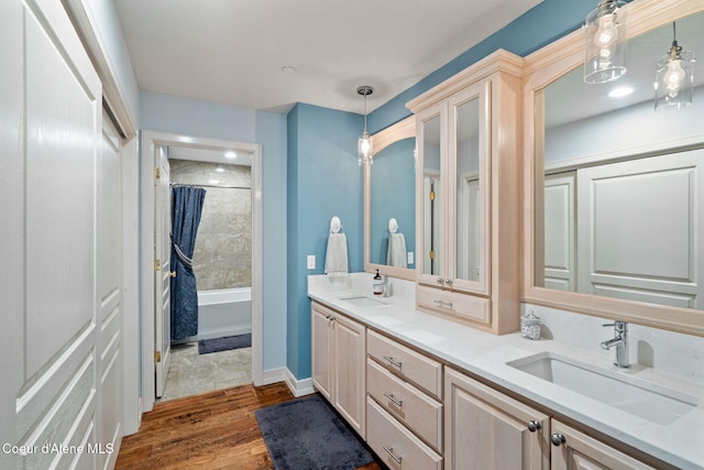 bathroom with hardwood / wood-style flooring, shower / bath combination with curtain, and vanity