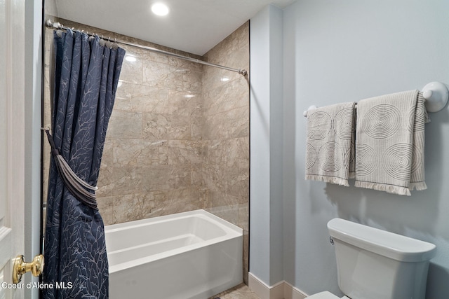 bathroom featuring toilet and shower / tub combo with curtain