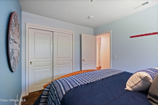 bedroom with dark hardwood / wood-style flooring and a closet