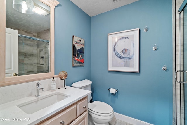 bathroom with a textured ceiling, a shower with door, vanity, and toilet