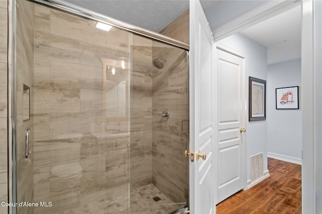 bathroom with wood-type flooring and a shower with door