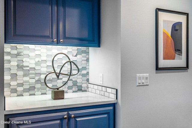 interior space with blue cabinetry and decorative backsplash