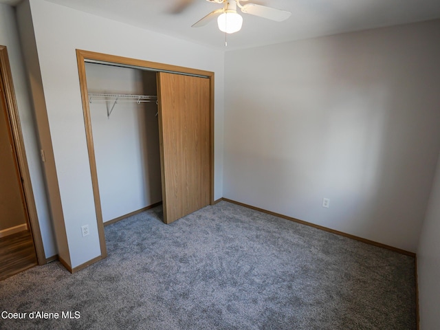 unfurnished bedroom featuring ceiling fan, a closet, and dark colored carpet