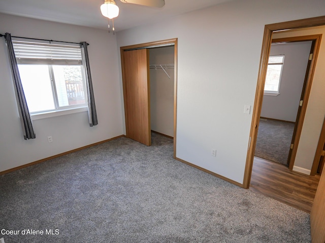 unfurnished bedroom featuring a closet, carpet flooring, multiple windows, and ceiling fan