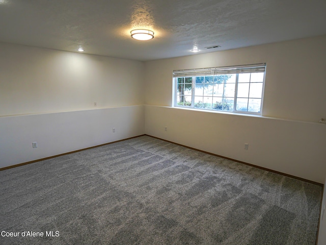 unfurnished room featuring a textured ceiling and carpet flooring