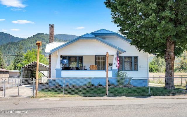 view of front facade with a mountain view, covered porch, and a carport