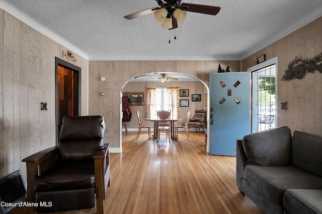 living room featuring light hardwood / wood-style floors, plenty of natural light, and wooden walls