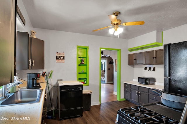 kitchen featuring dark brown cabinetry, black appliances, dark hardwood / wood-style flooring, sink, and ceiling fan