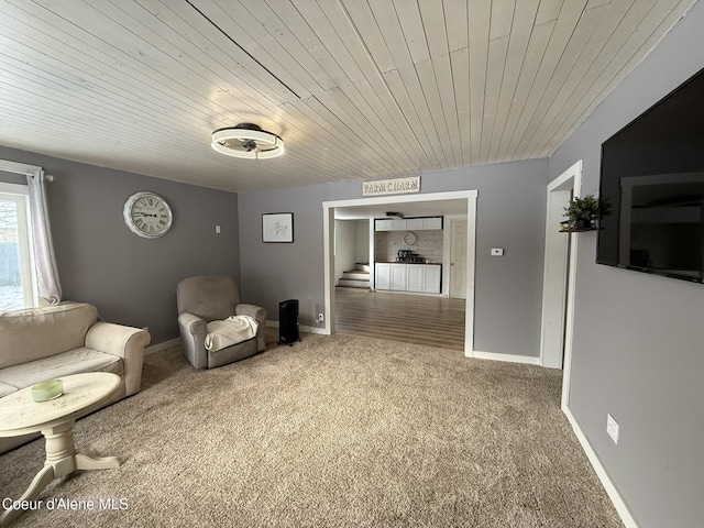 living area featuring wooden ceiling and carpet floors