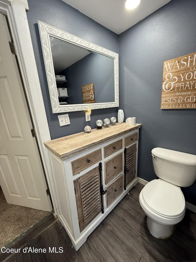 bathroom with toilet, hardwood / wood-style flooring, and vanity