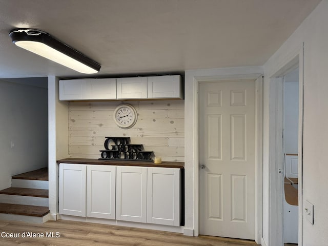 bar with white cabinets, light wood-type flooring, and butcher block countertops