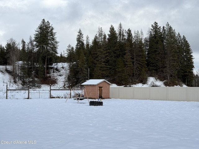 snowy yard featuring a storage shed