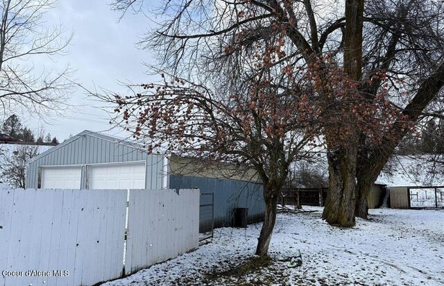 snow covered property with an outbuilding and a garage