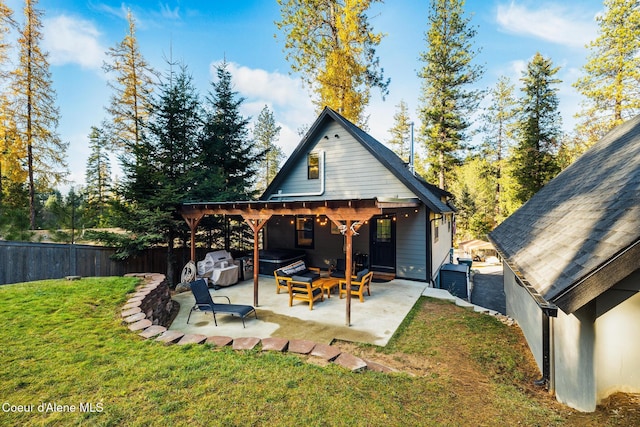 rear view of property with an outdoor hangout area, a patio area, and a lawn