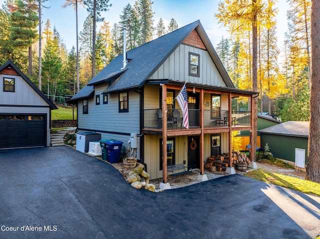 view of front facade featuring a balcony, a garage, and an outdoor structure