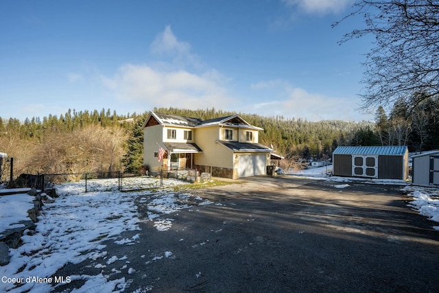 front of property with a garage and a storage shed