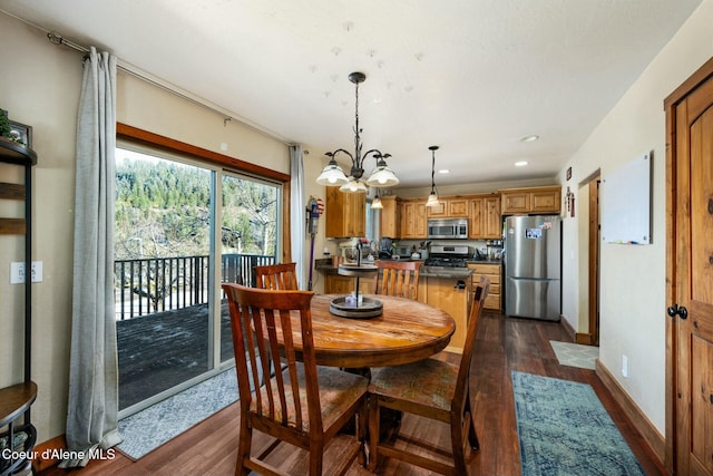 dining room with dark wood-type flooring and an inviting chandelier