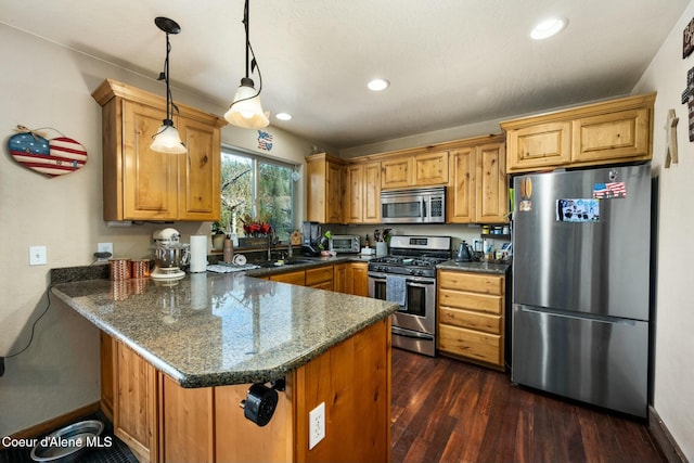 kitchen featuring kitchen peninsula, sink, hanging light fixtures, stainless steel appliances, and dark stone counters