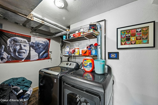 laundry area with a textured ceiling and washing machine and clothes dryer