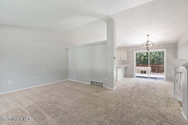 unfurnished living room with carpet, vaulted ceiling, a chandelier, and a textured ceiling