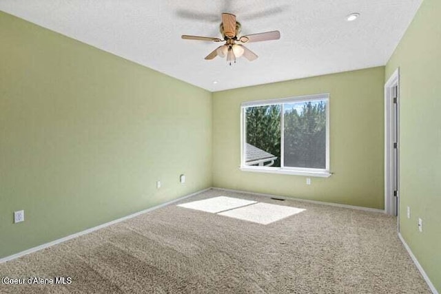 spare room with a textured ceiling, ceiling fan, and carpet