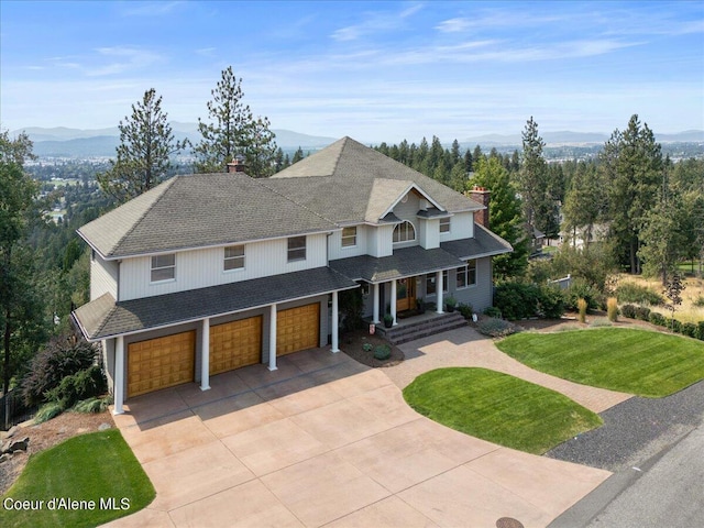 view of front facade with a front yard, a mountain view, and a garage