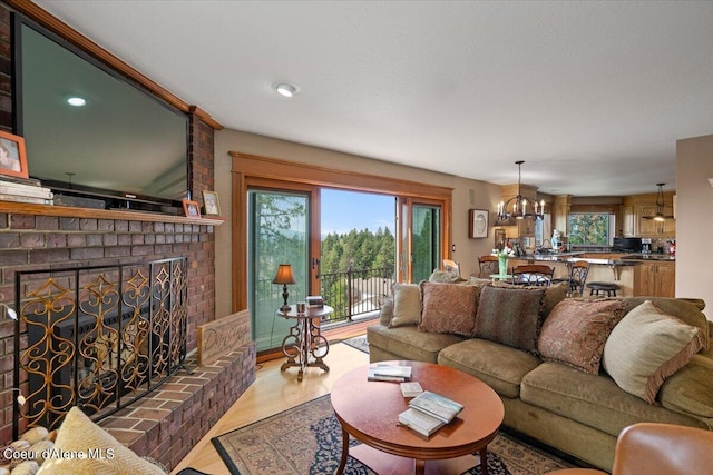 living room featuring a chandelier, light hardwood / wood-style floors, and a fireplace