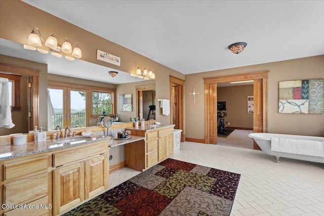 bathroom featuring a tub, vanity, and french doors