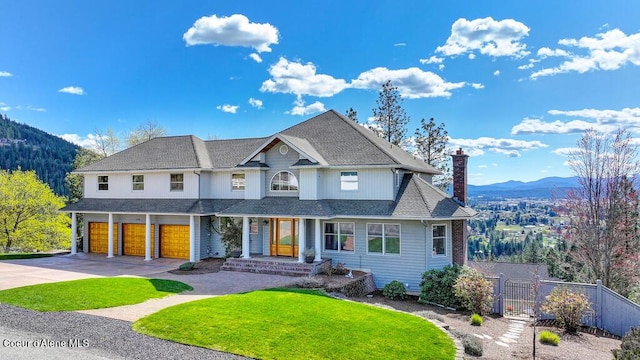 view of front facade featuring a chimney, driveway, an attached garage, a mountain view, and fence
