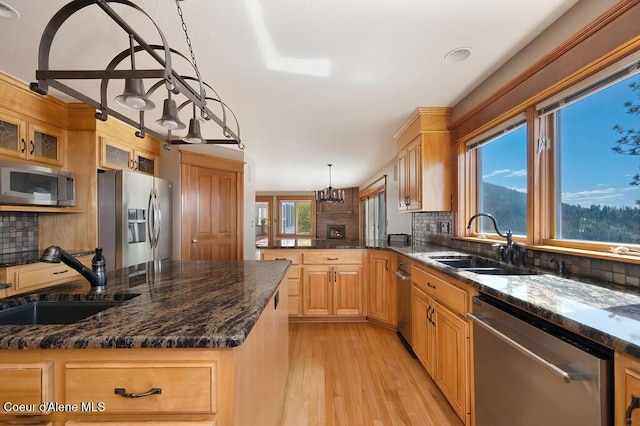 kitchen with backsplash, a peninsula, stainless steel appliances, and a sink