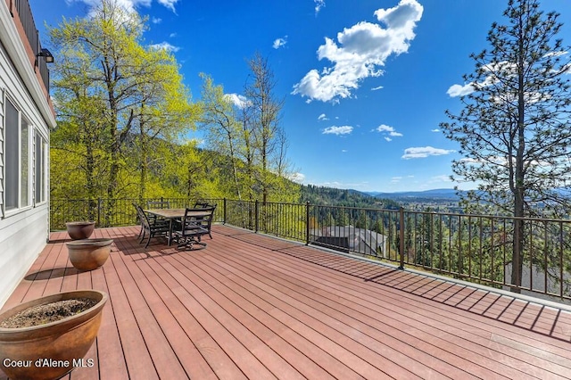 wooden deck featuring outdoor dining area and a mountain view