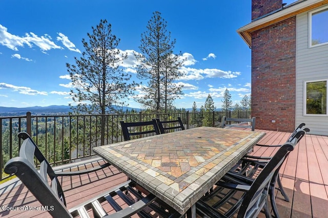 deck featuring outdoor dining area and a mountain view