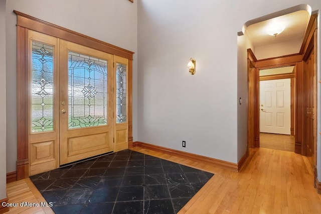 foyer with baseboards and dark wood-type flooring