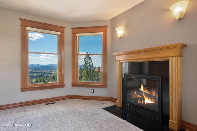 details with a fireplace with flush hearth, baseboards, visible vents, and carpet flooring