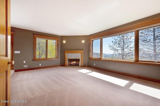 unfurnished living room with a fireplace, light carpet, and baseboards