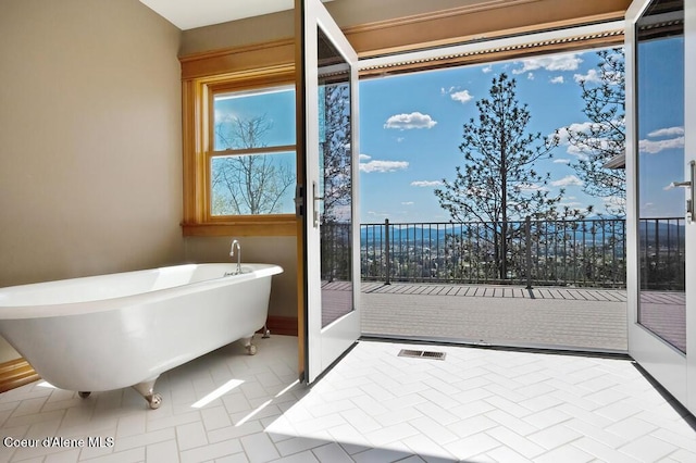 full bath featuring a freestanding tub and baseboards