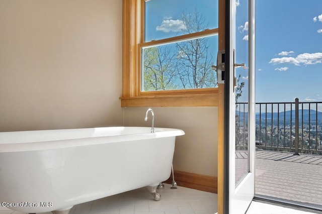 full bath featuring a freestanding tub and tile patterned floors