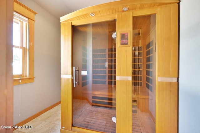 view of sauna / steam room with a healthy amount of sunlight, tile patterned floors, and baseboards