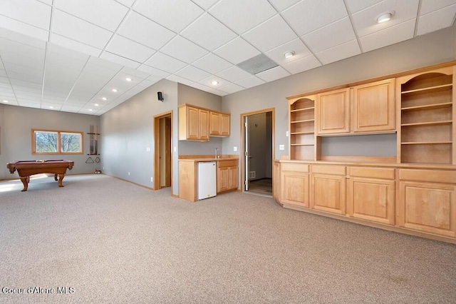 kitchen featuring light brown cabinetry, open shelves, dishwasher, light colored carpet, and open floor plan