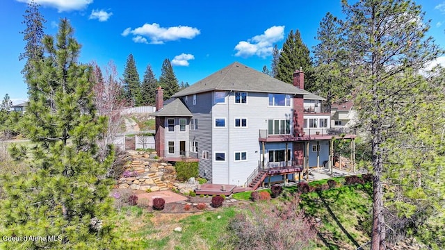 rear view of house with a chimney, stairs, and a deck