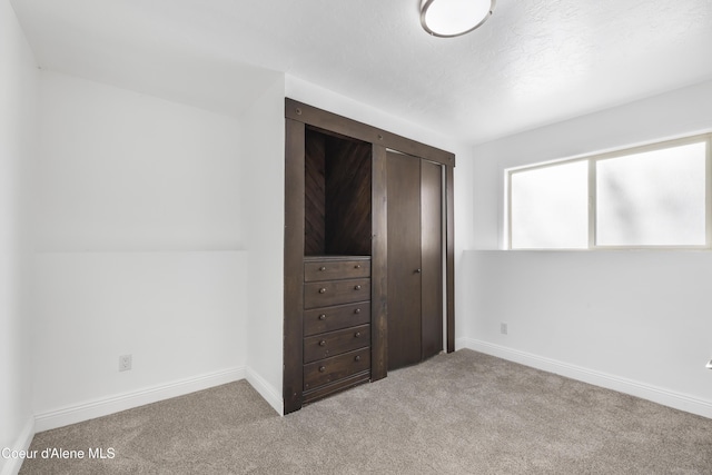 unfurnished bedroom featuring a closet and light carpet